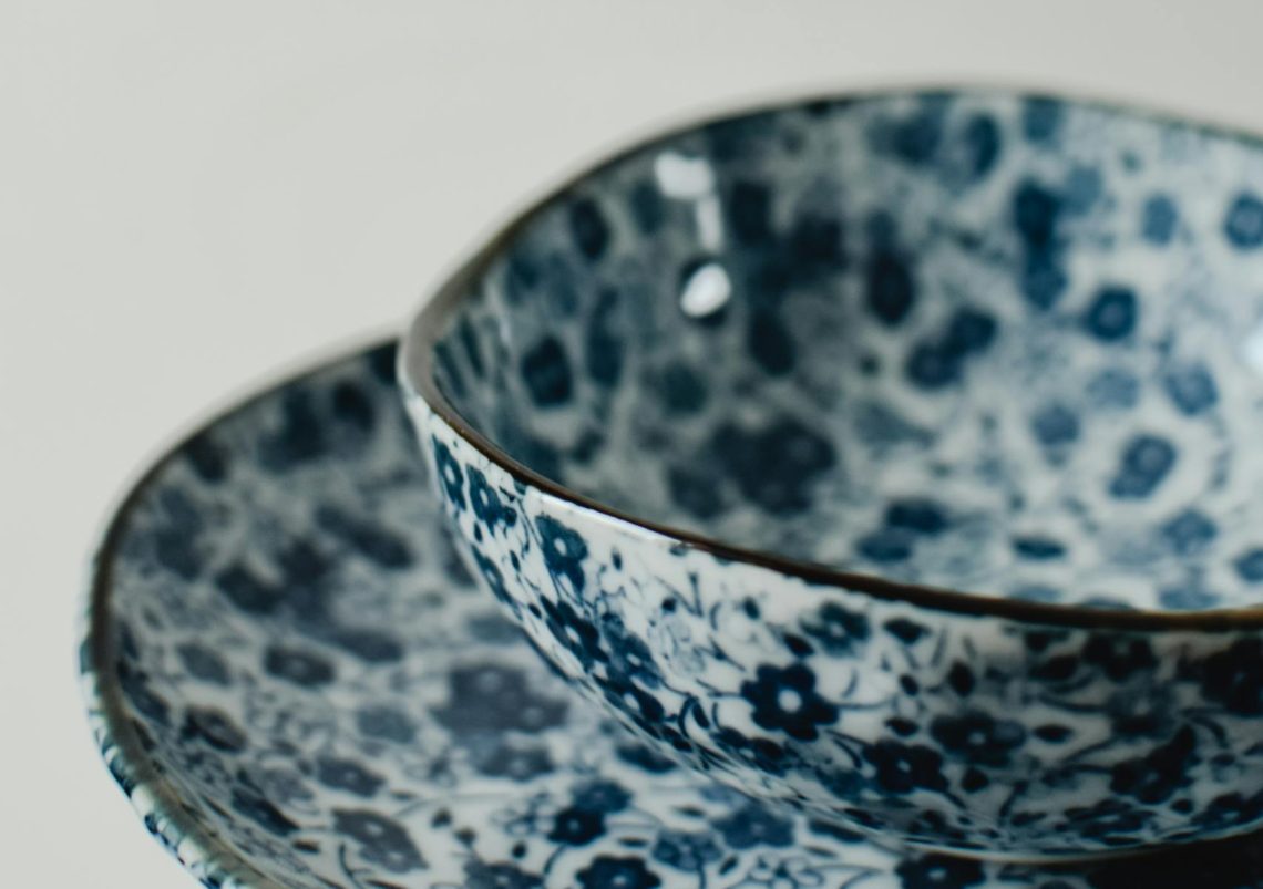 Elegant ceramic bowl with blue floral pattern, showcasing japandi minimalism in a vertical shot.