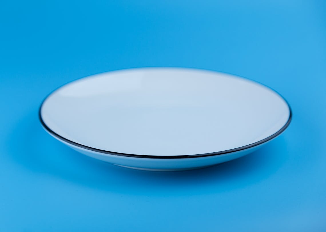 Elegant white plate set against a solid blue backdrop, showcasing simplicity.