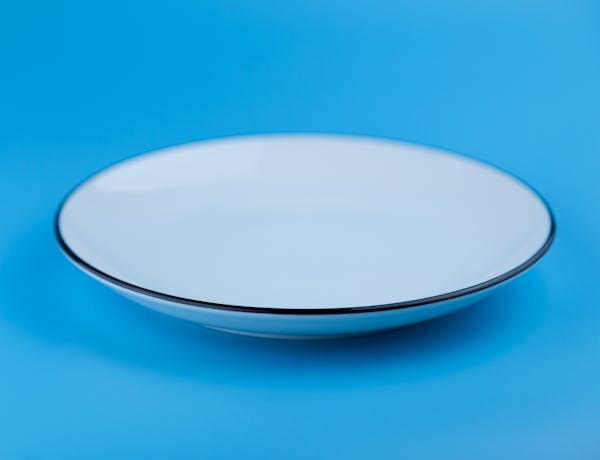 Elegant white plate set against a solid blue backdrop, showcasing simplicity.